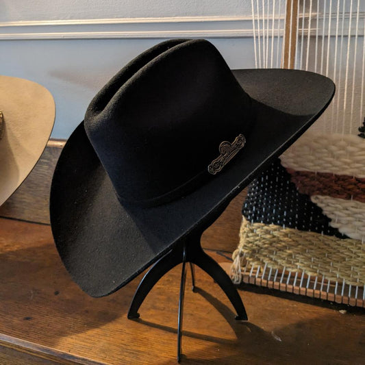 Black Felt cowboy style hat on a stand 